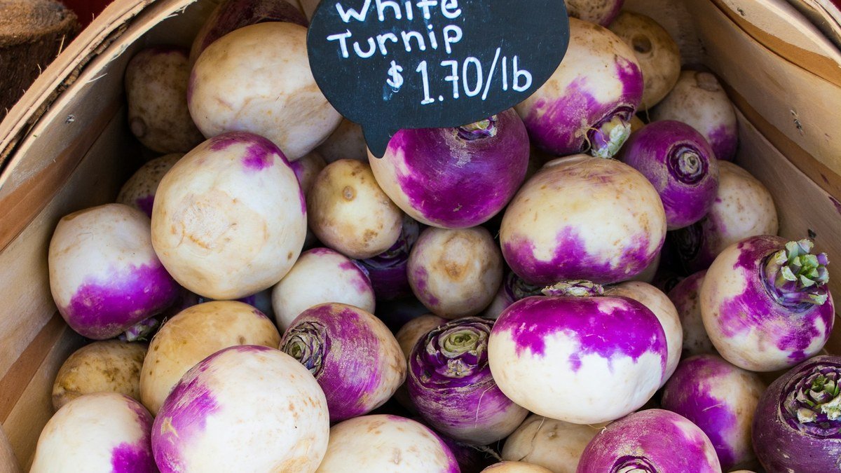 Real white and purple turnips in a market basket