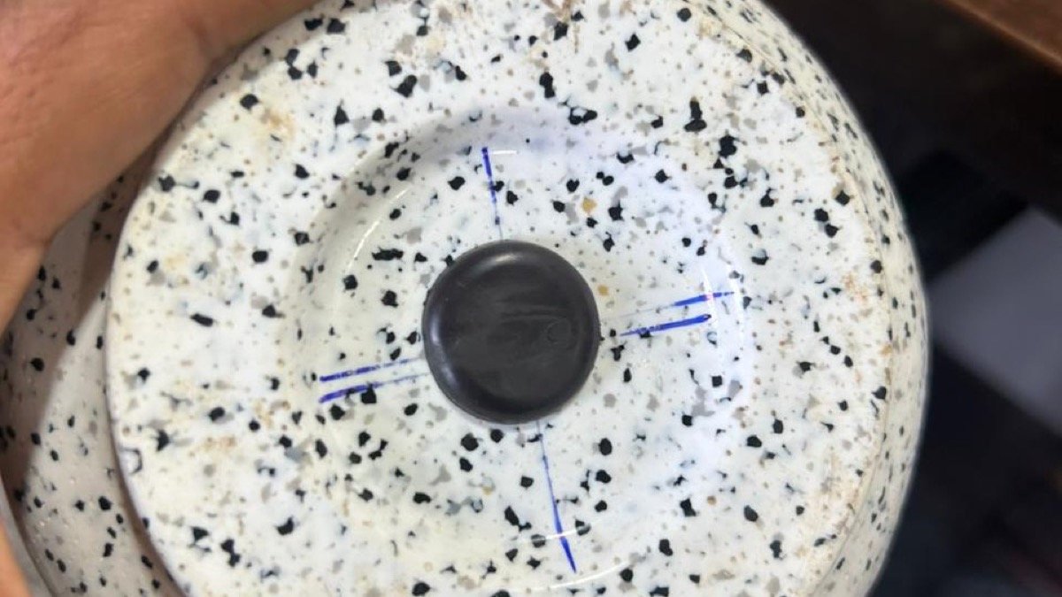 The bottom of a real planter with a removable drainage plug